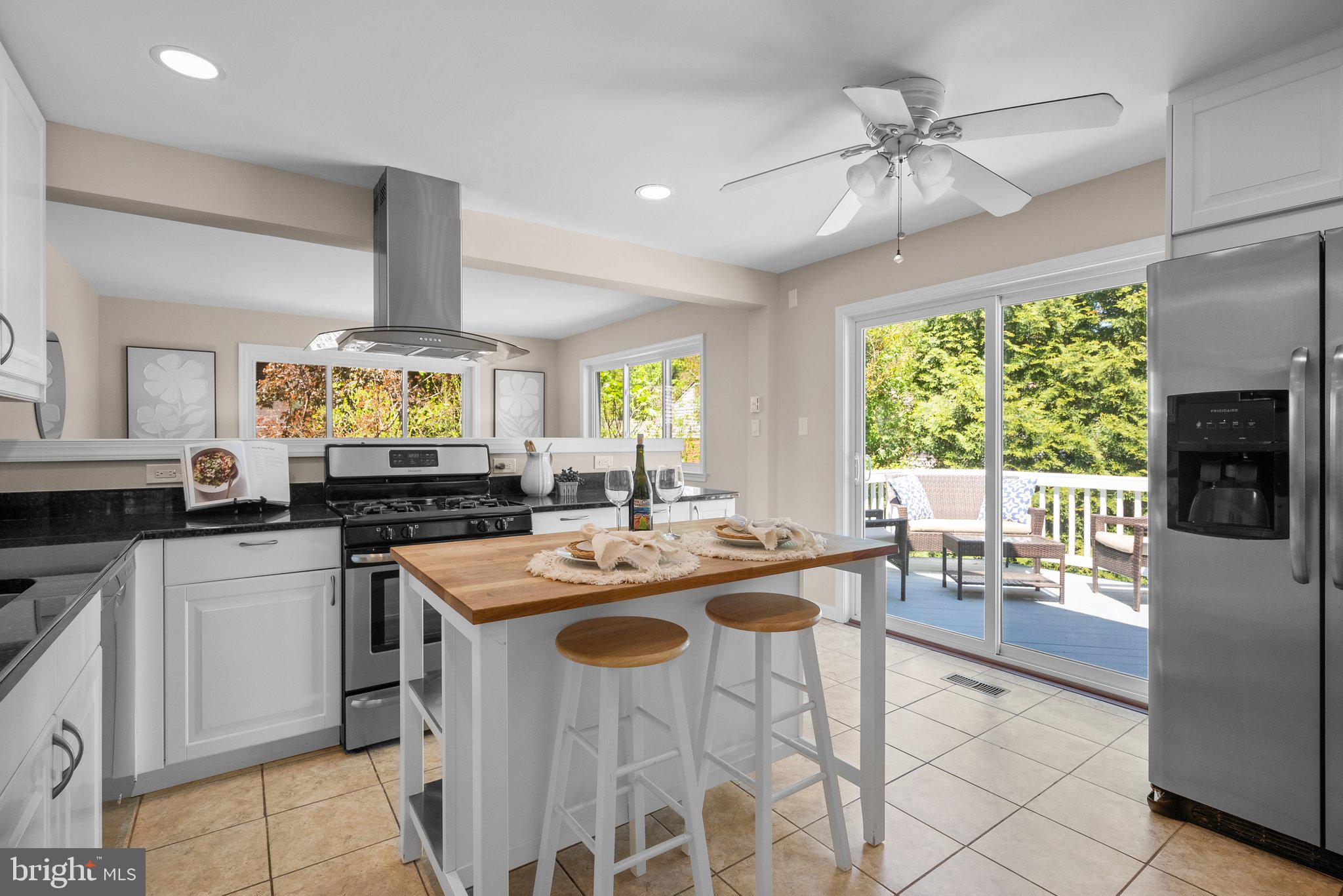 1007 Helena Drive Silver Spring, MD 20901 - Photo 6 of 39 a kitchen with a stove a sink a kitchen island with chairs and wooden floor