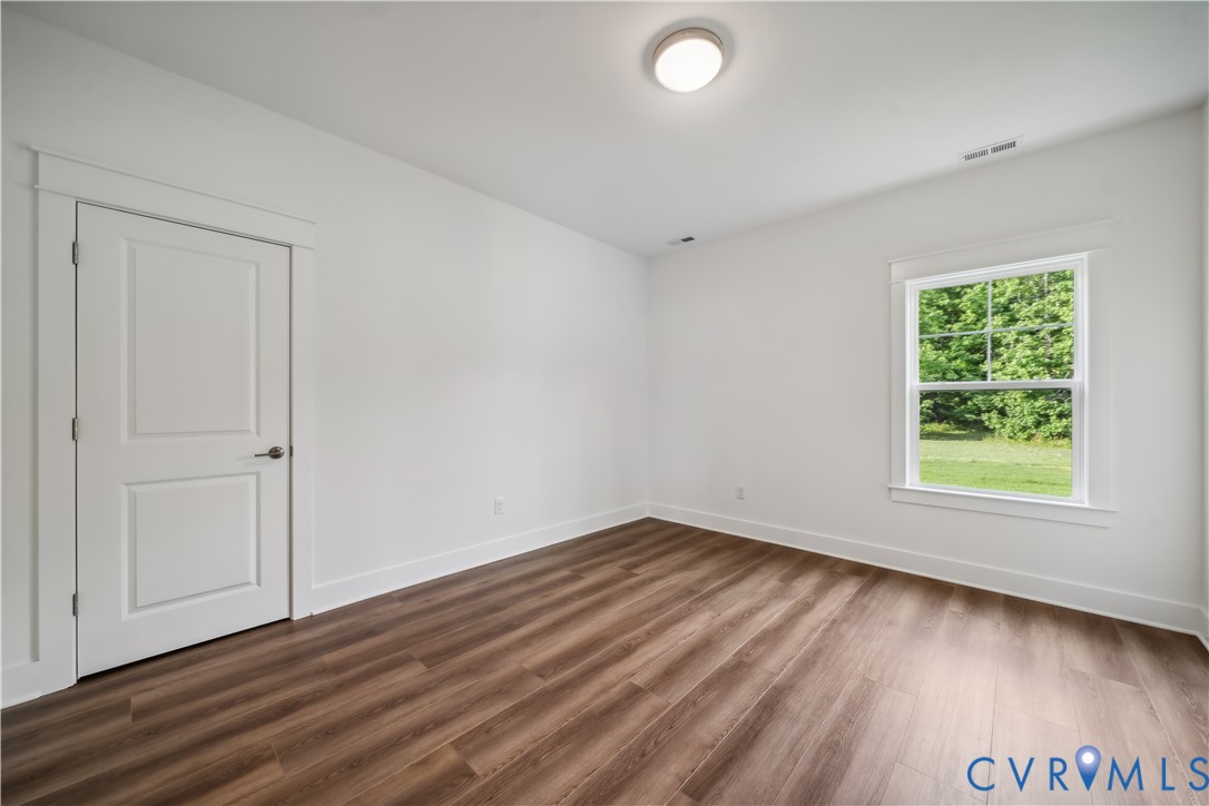 114 Logan Way Tappahannock, VA 22560 - Photo 24 of 28 an empty room with wooden floor and windows