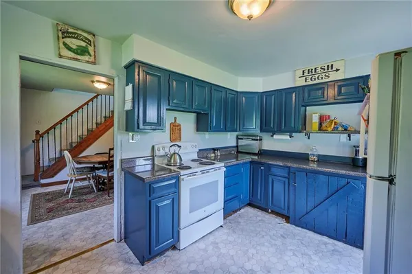 a kitchen with granite countertop a table chairs stove and cabinets