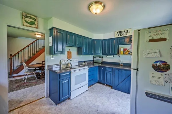 a kitchen with granite countertop a stove a sink and a wooden cabinets