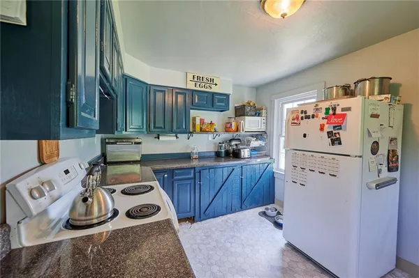 a kitchen with a refrigerator a stove and wooden floor