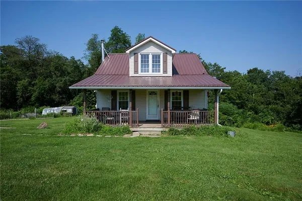 a front view of a house with a garden and porch