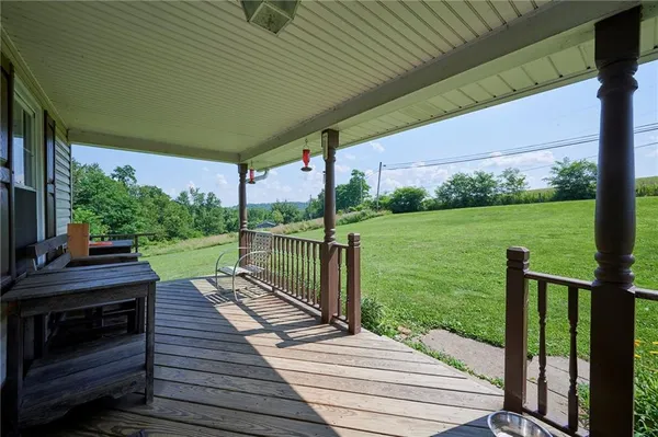 a patio with wooden floor table and chairs