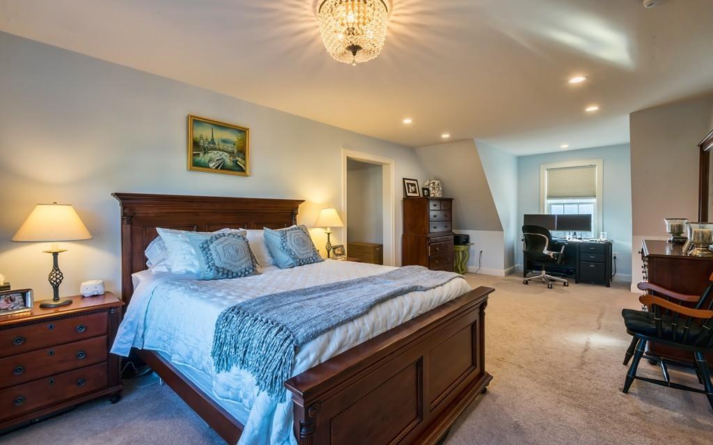 10 Intervale Road Marblehead, MA 01945 - Photo 13 of 32 a spacious bedroom with a bed and a chandelier