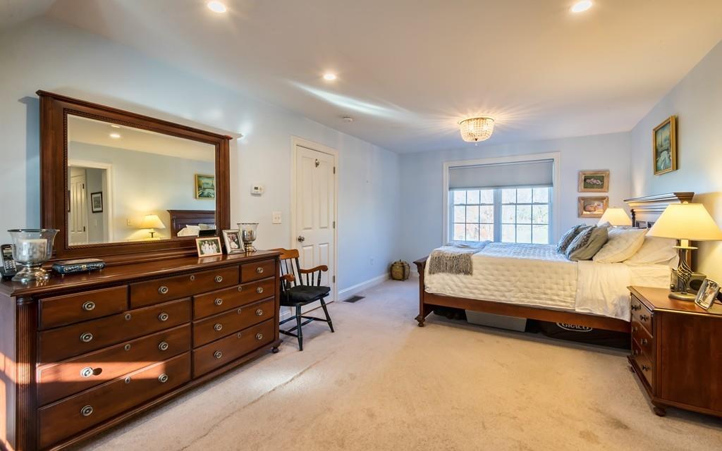 10 Intervale Road Marblehead, MA 01945 - Photo 14 of 32 a spacious bedroom with a bed and dresser with mirror