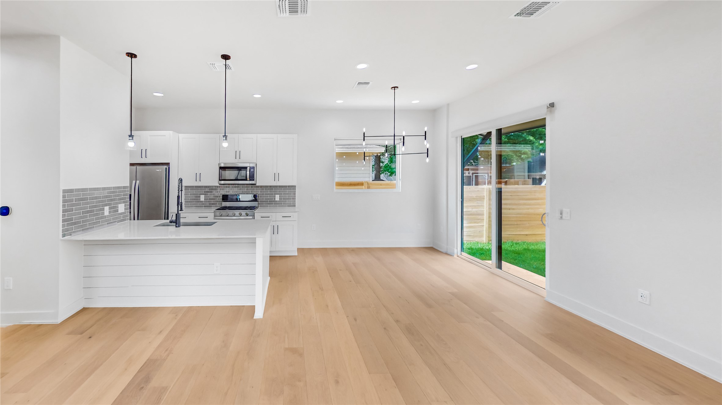 4424 Hank Avenue, Unit 2 Austin, TX 78745 - Photo 5 of 11 Modern kitchen with sleek stainless steel appliances flows seamlessly into an airy dining and living space.