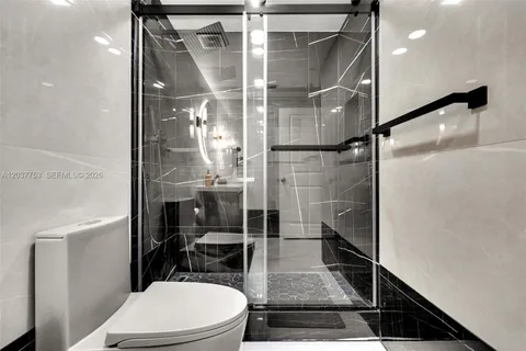 a bathroom with a toilet and a shower