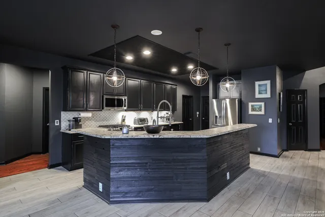 a kitchen with kitchen island granite countertop wooden cabinets and a sink