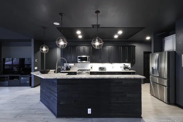 a kitchen with kitchen island a sink stainless steel appliances and cabinets