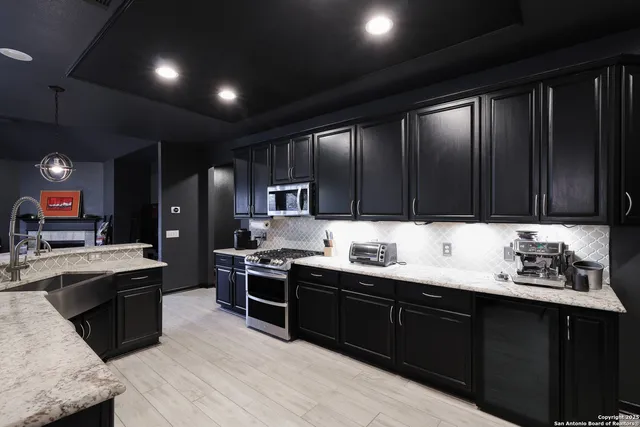 a kitchen with stainless steel appliances kitchen island granite countertop a sink counter space cabinets and a sink