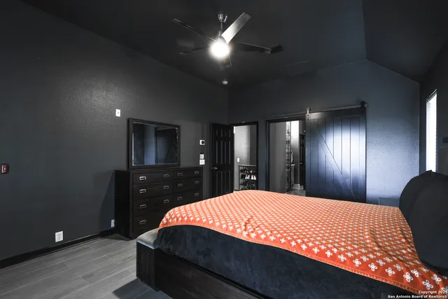 a bedroom with a bed and a lamp on dresser