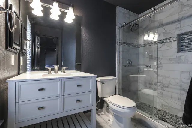 a bathroom with a sink a toilet and shower