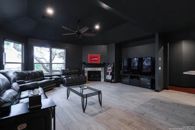 a living room with furniture a flat screen tv and a fireplace