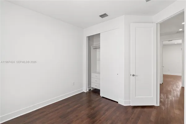 a view of an empty room with wooden floor