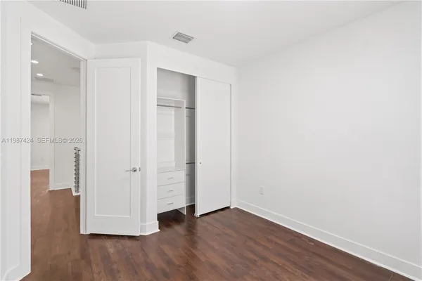 a view of an empty room with wooden floor
