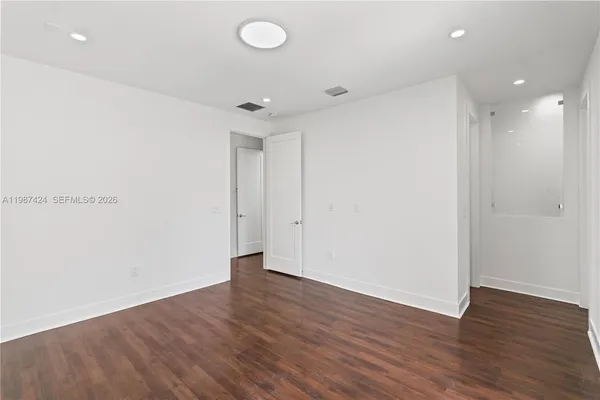a view of an empty room with wooden floor