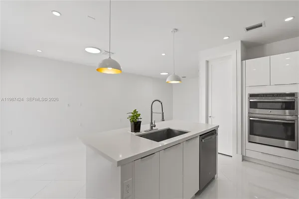 a kitchen with stainless steel appliances a sink a stove and a refrigerator