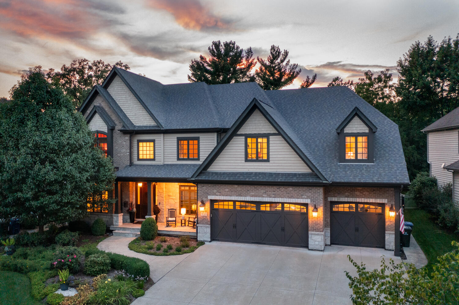 a front view of a house with a yard and potted plants
