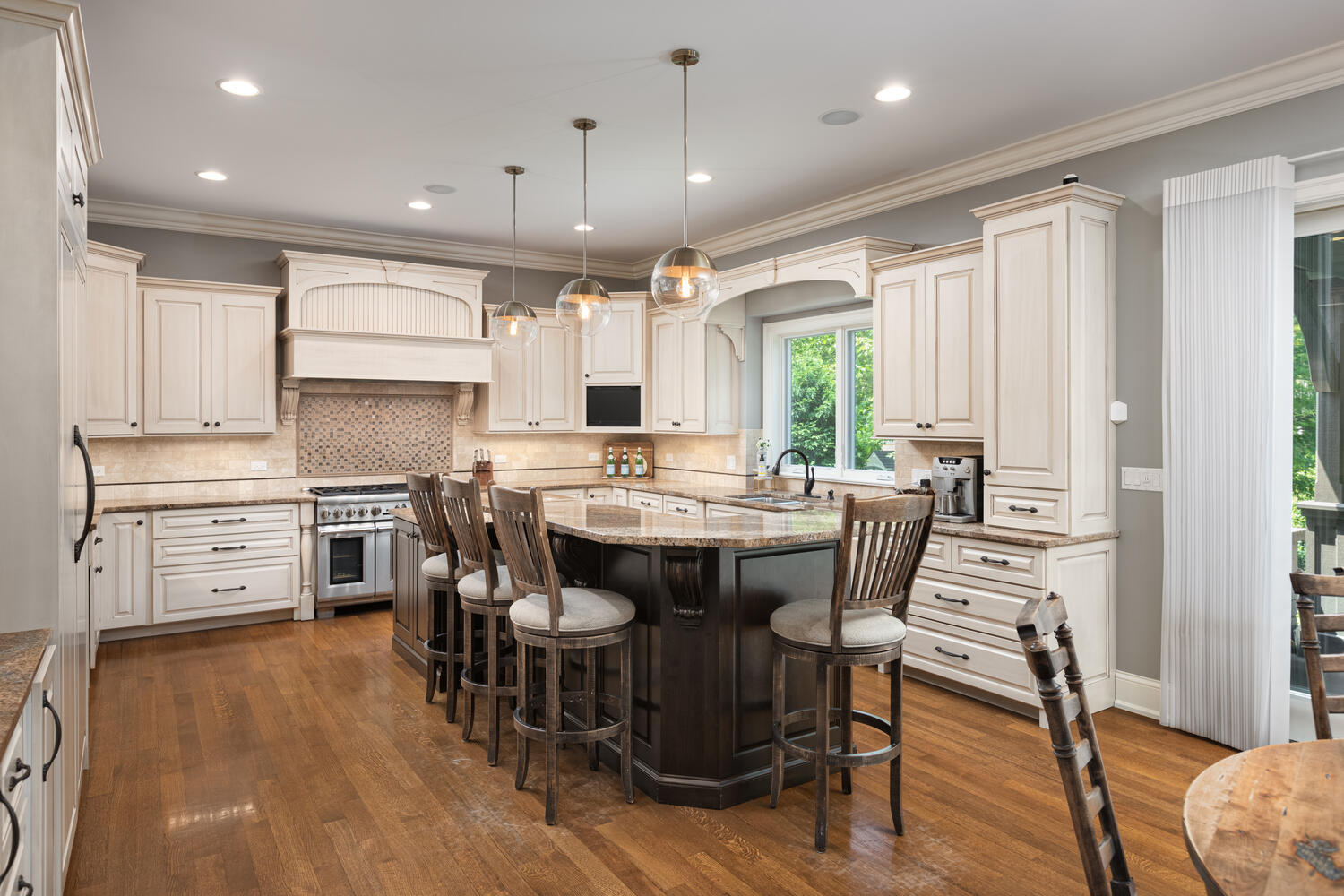 833 Wellner Road Naperville, IL 60540 - Photo 10 of 59 a kitchen with stainless steel appliances kitchen island wooden floors and white cabinets