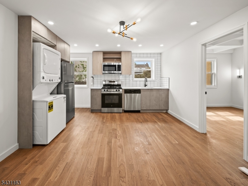 100 Chestnut Street, Unit 3 West Orange, NJ 07052 - Photo 3 of 18 a large kitchen with stainless steel appliances granite countertop a lot of counter space and wooden floors