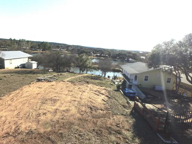 a view of a dry yard with wooden fence