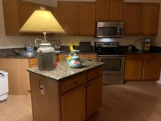 a kitchen with stainless steel appliances granite countertop a stove a sink and a microwave