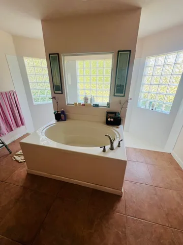 a bath tub sitting in a bathroom next to a window