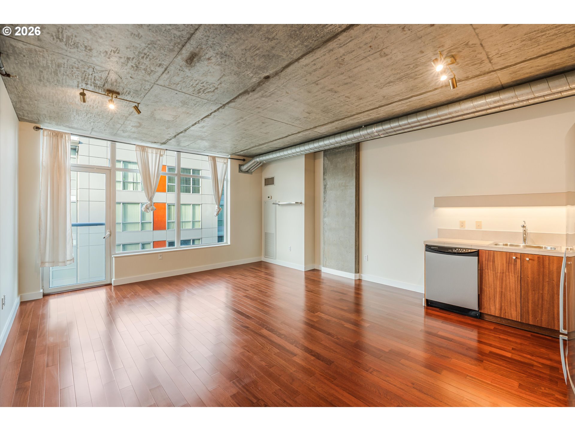 1926 West Burnside Street, Unit 512 Portland, OR 97209 - Photo 2 of 18 a view of an empty room with wooden floor and a window