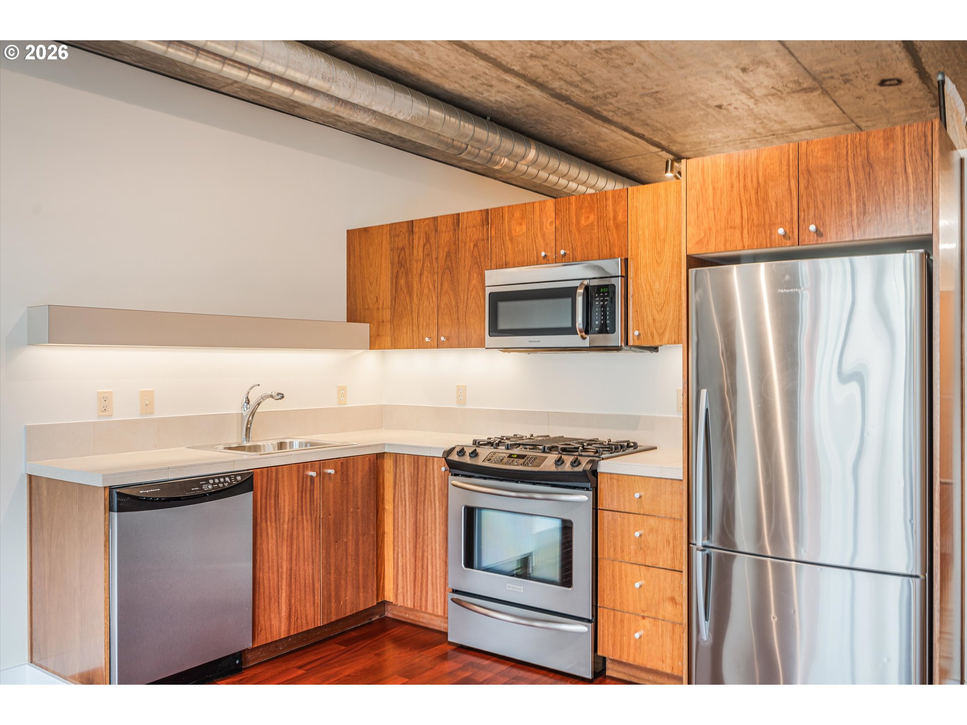 1926 West Burnside Street, Unit 512 Portland, OR 97209 - Photo 3 of 18 a kitchen with granite countertop a sink stove and refrigerator