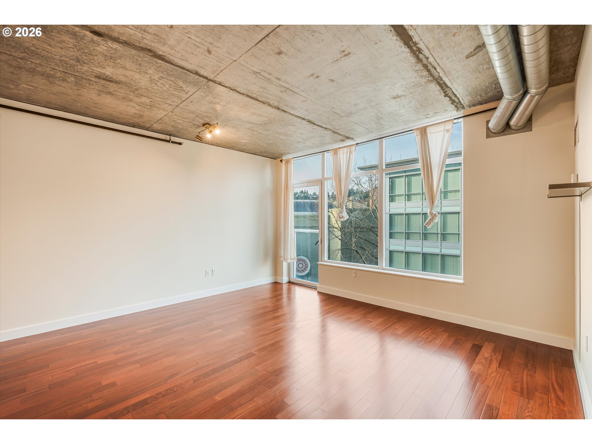 1926 West Burnside Street, Unit 512 Portland, OR 97209 - Photo 6 of 18 a view of an empty room with wooden floor and a window