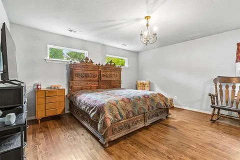 a bedroom with a bed and a chandelier
