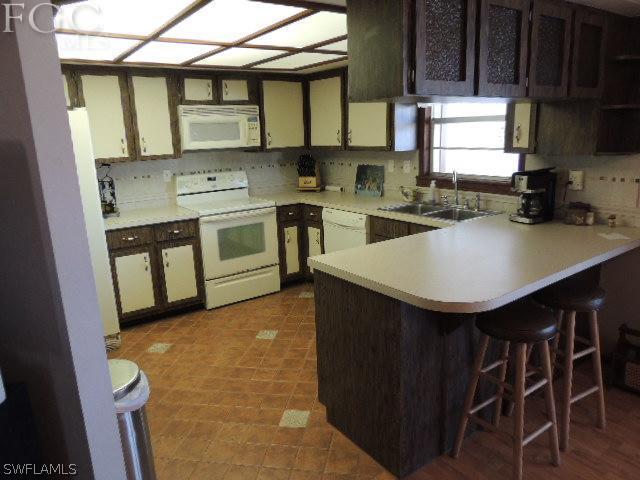 3197 Stabile Road St. James City, FL 33956 - Photo 10 of 17 a kitchen with stainless steel appliances a stove a sink a microwave a refrigerator and cabinets