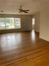 a view of a livingroom with wooden floor and a window