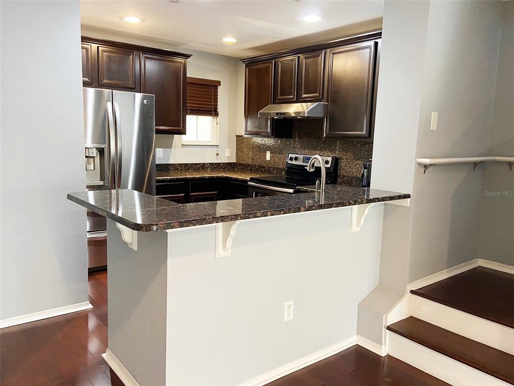 8946 White Sage Loop Lakewood Ranch, FL 34202 - Photo 11 of 36 a kitchen with stainless steel appliances a refrigerator stove and microwave