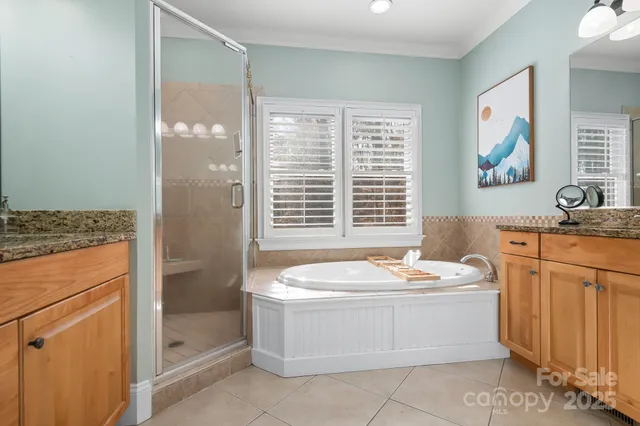 a bathroom with a granite countertop sink a mirror and a bathtub