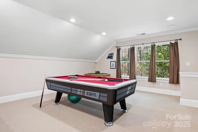 a room with pool table and windows