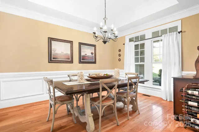 a view of a dining room with furniture wooden floor and chandelier