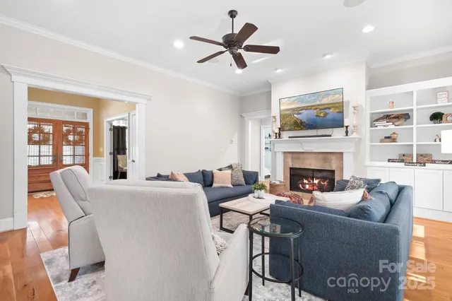 a living room with furniture a fireplace and a flat screen tv