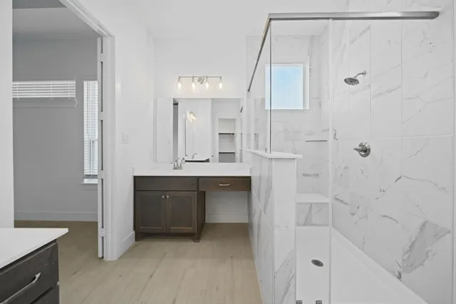 a bathroom with a double vanity sink mirror and shower