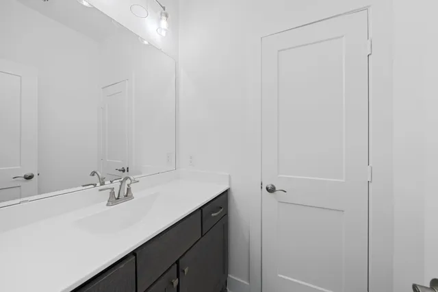 a bathroom with a sink vanity and a mirror