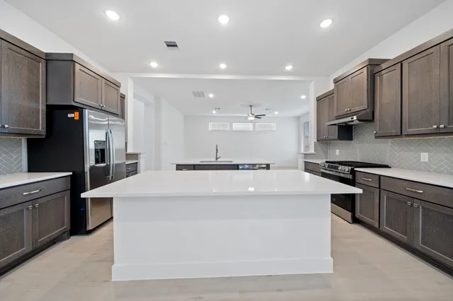 a large kitchen with stainless steel appliances kitchen island a stove and a sink