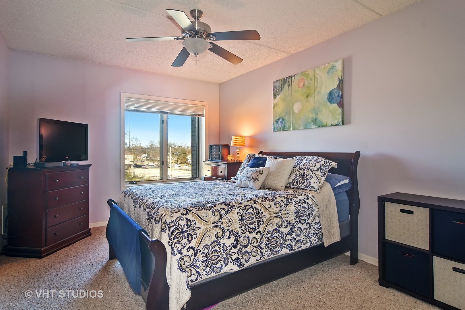 5 West Central Road, Unit 412 Mount Prospect, IL 60056 - Photo 6 of 10 a bedroom with a large bed and a flat tv screen on dresser