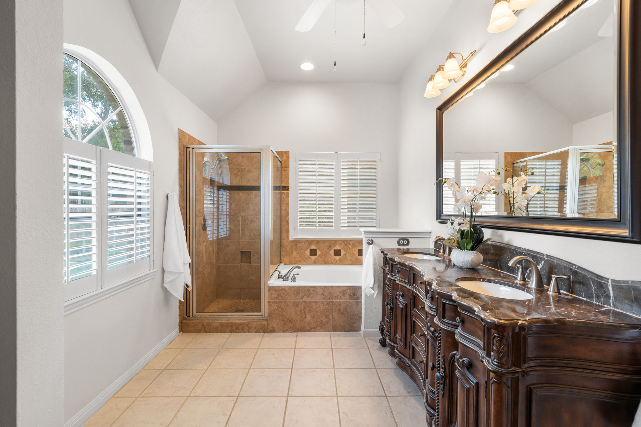 819 Blue Spring Circle Round Rock, TX 78681 - Photo 16 of 36 High vaulted ceilings and stone-topped vanities define this classic bathroom space.
