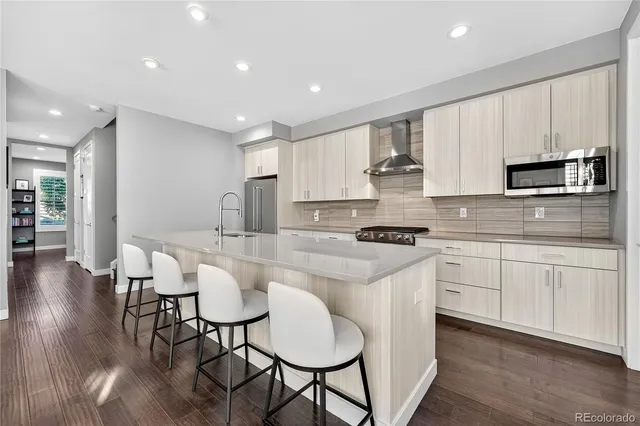 a kitchen with stainless steel appliances granite countertop a stove a sink a microwave a center island and furniture