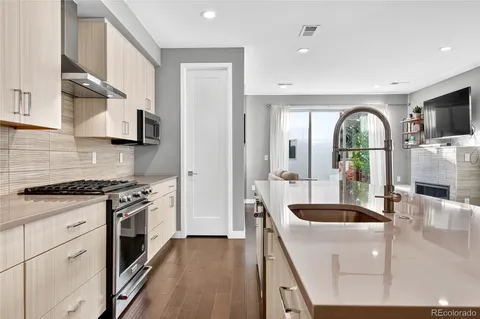 a kitchen with stainless steel appliances granite countertop a stove a sink and a refrigerator