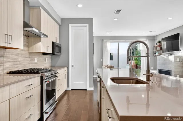 a kitchen with stainless steel appliances granite countertop a stove a sink and a refrigerator