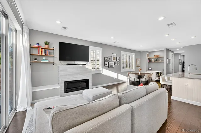 a living room with furniture a fireplace and a flat screen tv