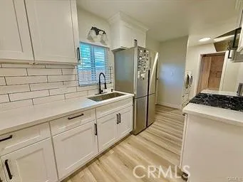 a kitchen with granite countertop a refrigerator and a sink
