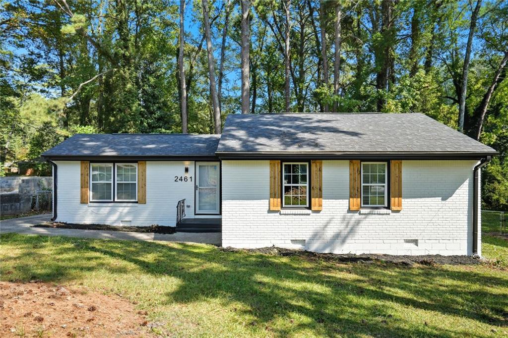 2461 Old Colony Road Atlanta, GA 30344 - Photo 1 of 1 a front view of a house with a yard table and chairs