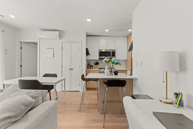 a living room with stainless steel appliances kitchen island granite countertop furniture and a couch